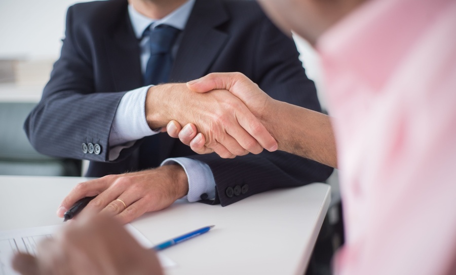 Asesor inmobiliario y cliente firmando un acuerdo de comisión en la reunión