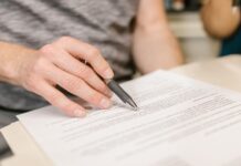 Contrato de arrendamiento para departamentos compartidos (roomies): qué debe incluir y cómo proteger a todas las partes Persona firmando un contrato de arrendamiento para departamento compartido con roomies
