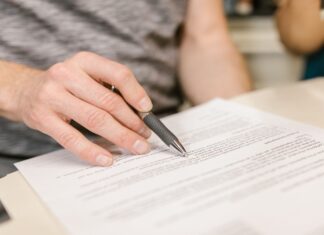 Contrato de arrendamiento para departamentos compartidos (roomies): qué debe incluir y cómo proteger a todas las partes Persona firmando un contrato de arrendamiento para departamento compartido con roomies