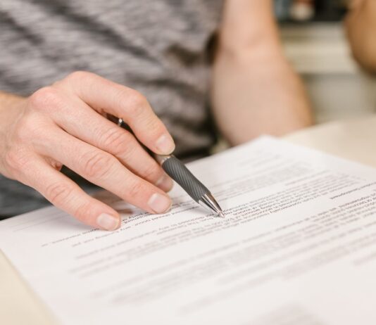 Contrato de arrendamiento para departamentos compartidos (roomies): qué debe incluir y cómo proteger a todas las partes Persona firmando un contrato de arrendamiento para departamento compartido con roomies