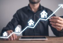 Leads inmobiliarios: 5 errores de gestión que frenan tus ventas Agente inmobiliario señalando un gráfico ascendente que representa el crecimiento en la gestión de leads inmobiliarios